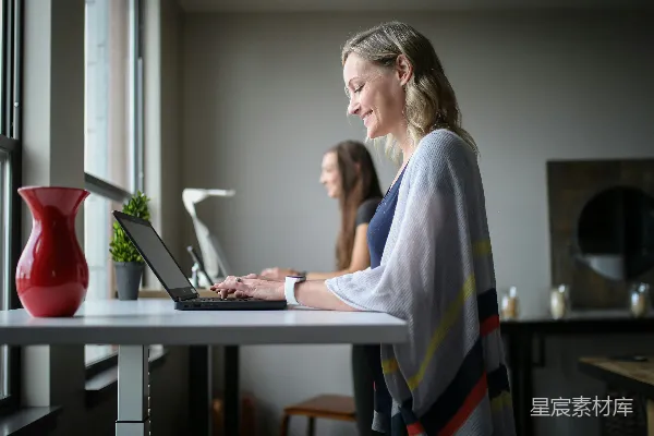 高清摄影 穿着灰色背心的女人在使用MacBook Air。