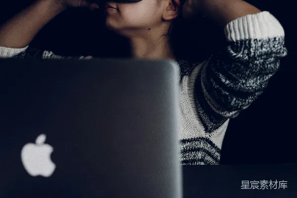 高清摄影 戴着黑色虚拟现实头显的女性正对着MacBook