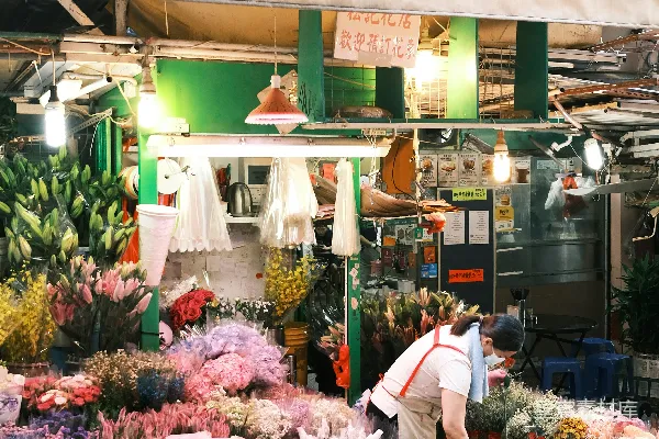 高清摄影 一个男人站在一家满是鲜花的商店前面。