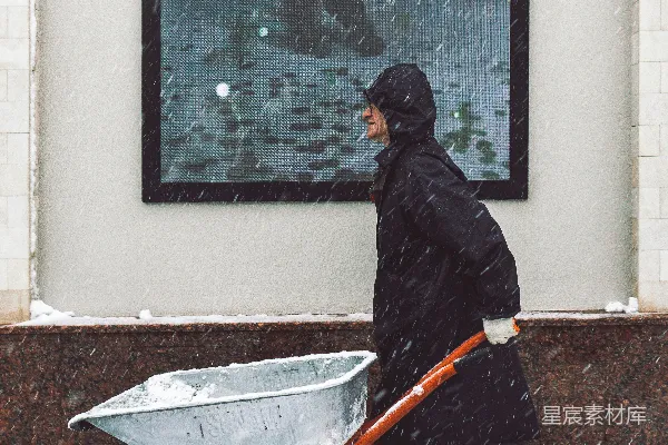 高清摄影 一个男人在雪地里推着手推车