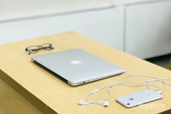 高清摄影 银色MacBook放在眼镜和iPhone旁边。