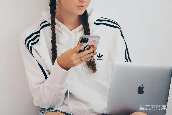 高清摄影 穿白大褂的女士坐在床上使用银色的MacBook。