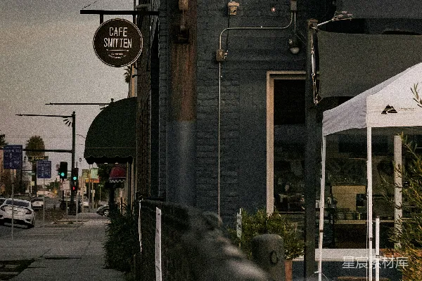 高清摄影 白天，道路旁边的一座白棕色混凝土建筑。