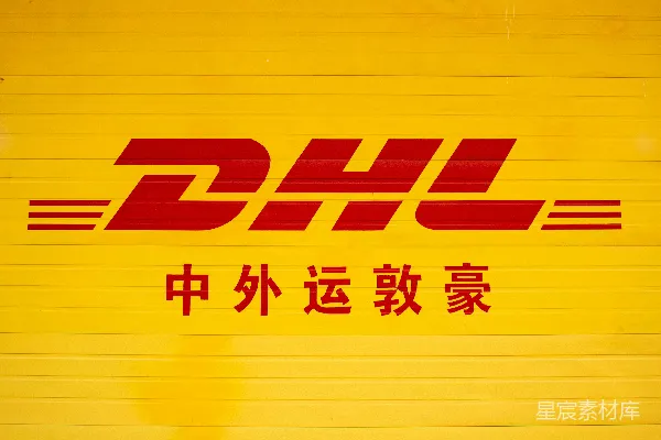 高清摄影 一堵黄色的墙，上面有一个红色的DHL标志。