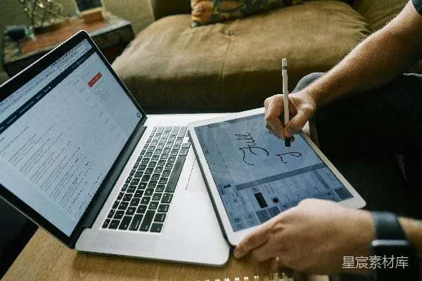 高清摄影 一个人在棕色沙发上使用MacBook Pro。
