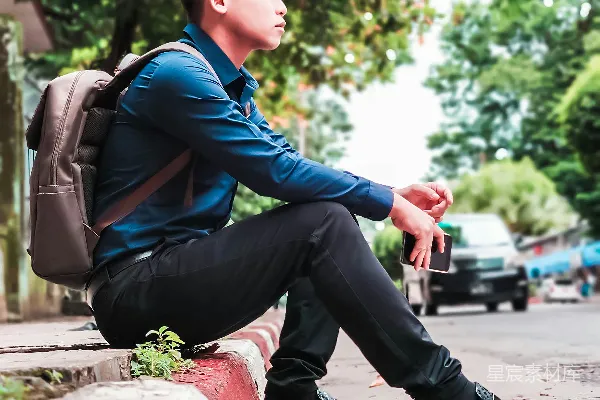 高清摄影 穿着蓝色夹克和黑色裤子的男孩坐在白天的混凝土长椅上。