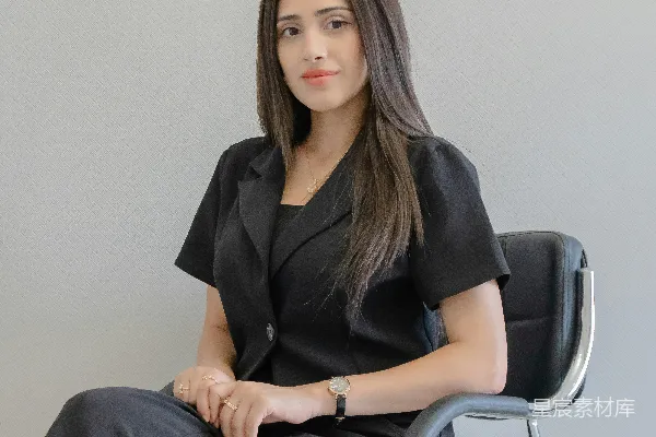高清摄影 一个穿着黑色西装的女人坐在椅子上。