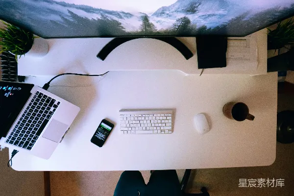 高清摄影 打开笔记本电脑，附近有智能手机、Apple键盘和Magic Mouse，放在白色的电脑桌上。