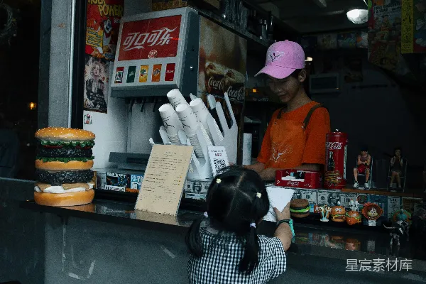 高清摄影 一个小女孩站在一家快餐店前面。