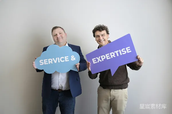 高清摄影 两名面带微笑的男子，手里举着“service”和“expertise”的牌子。