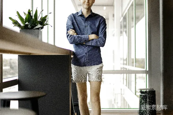 高清摄影 穿蓝色牛仔夹克和白色裙子的女人站在棕色木桌旁。