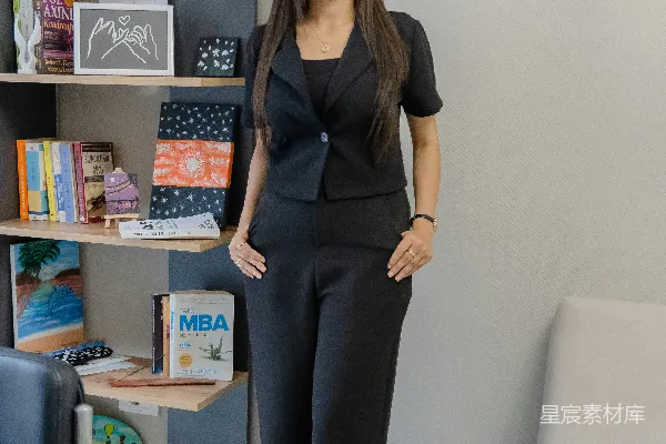 高清摄影 一个穿着黑色西装的女人站在书架旁。