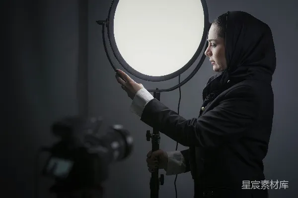 高清摄影 穿着黑色连帽衫的女子拿着一面圆镜