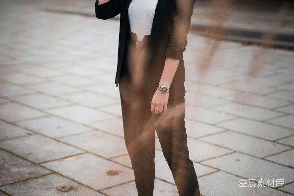 高清摄影 穿黑色夹克和棕色裤子的女人在白天站在人行道上。
