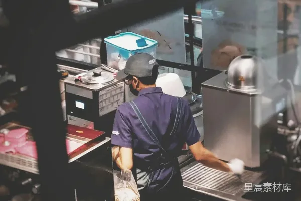 高清摄影 在一家商用厨房工作的人正在准备食物。