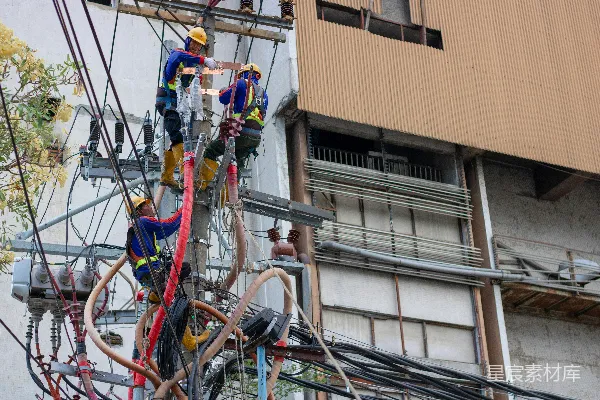 高清摄影 一群人正在修理电线杆上的电线。