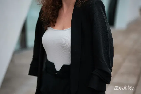 高清摄影 穿着黑色西装外套的女人站在灰色混凝土地板上