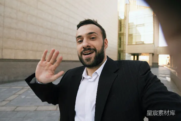 高清摄影 穿着西装的男人在现代化建筑外挥手打招呼。