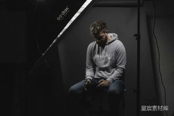 高清摄影 穿着灰色毛衣的男人坐在黑色椅子上。