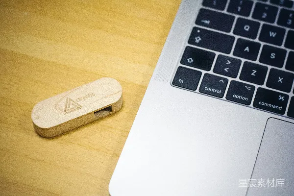 高清摄影 棕色拇指驱动器放在MacBook旁边