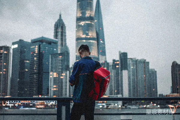 高清摄影 穿着红色连帽衫和黑色裤子的男人站在黑色金属栏杆上。