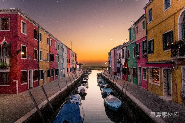 高清摄影 在夕阳下，多色建筑之间停泊着蓝色的小船。
