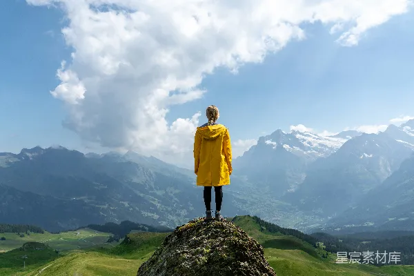 高清摄影 白天，一名女子站在岩石前，面对着山。