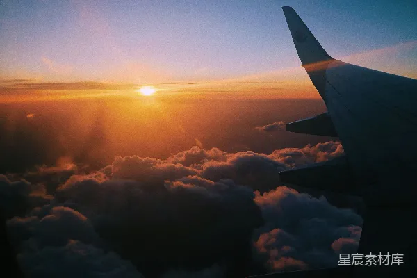 高清摄影 夕阳下，飞机穿越云层