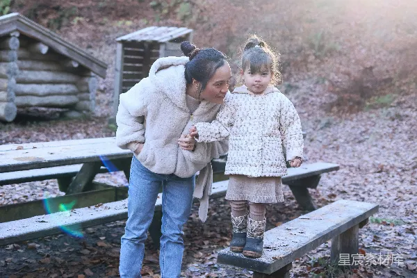 高清摄影 一对母子在树林中的野餐长椅上。