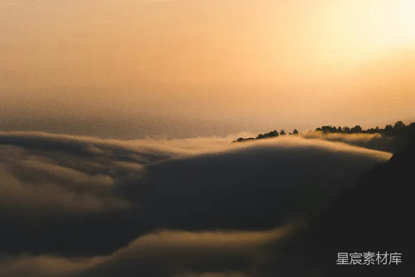 高清摄影 夕阳正从山峦中的云层后落下。