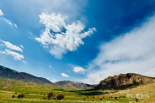 高清摄影 一条山谷的风景，背景是连绵的山脉。