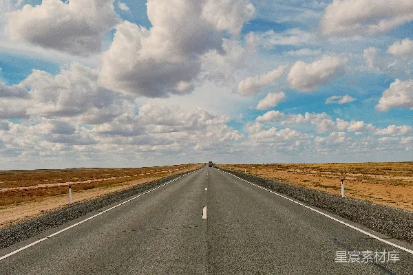 高清摄影 一条长长的空旷的路，天空中布满了云层。