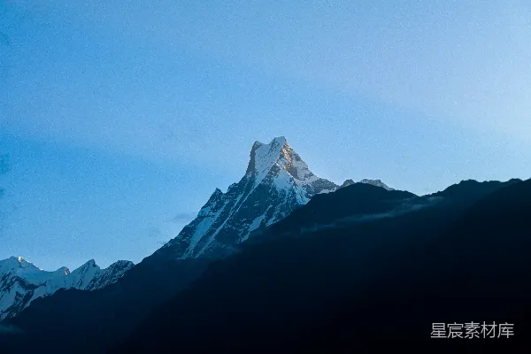 高清摄影 一座被雪覆盖的山峰，背景是蓝天。