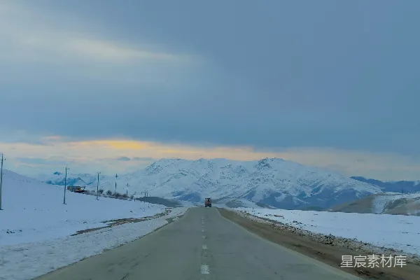 高清摄影 一条道路，背景是被雪覆盖的山脉。