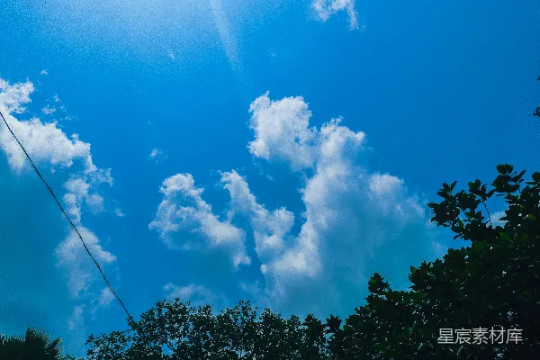 高清摄影 阳光透过树木上方的云层照耀下来。