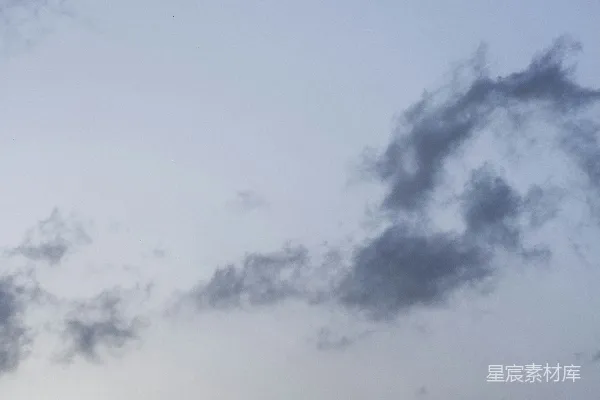 高清摄影 天空中的一架飞着的飞机，云朵环绕在它周围。