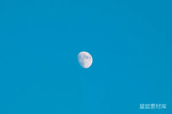 高清摄影 一片清澈的蓝天，挂着一轮半圆的月亮。