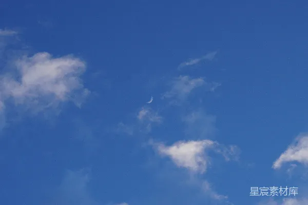 高清摄影 一架飞机在空中飞行，远处有一轮弯月。