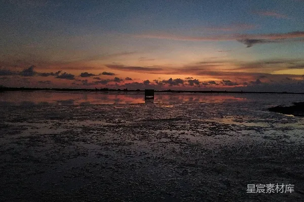 高清摄影 剪影中的人站在海码头上，背景是夕阳。