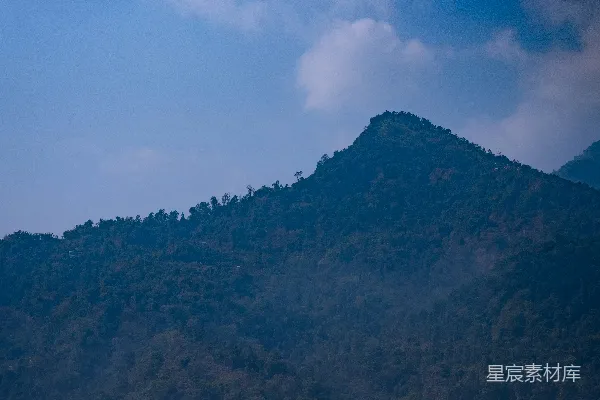 高清摄影 一座大山，山上长着树木。