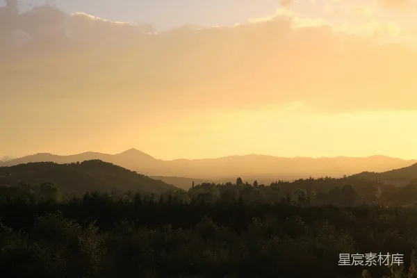 高清摄影 夕阳正落山，远处的群山笼罩在余晖之中。