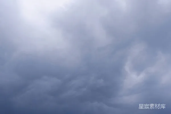 高清摄影 一群人在阴云密布的天空下站在海滩上。