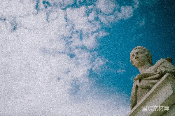 高清摄影 一座雕像矗立在建筑物的顶端，天空布满了云层。