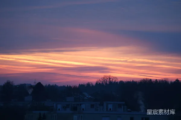 高清摄影 绚丽的夕阳天空，映衬着剪影的树木和建筑。