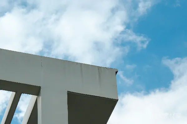 高清摄影 一座建筑物侧面挂着的钟表，在阴云密布的天空下。