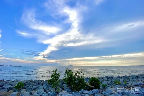 高清摄影 一个岩石海滩，背景中有一片水域。