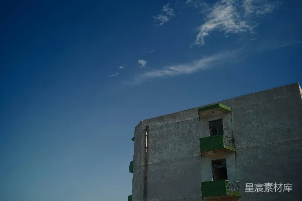 高清摄影 一座高大的建筑物，绿意盎然的阳台在蓝天之下。
