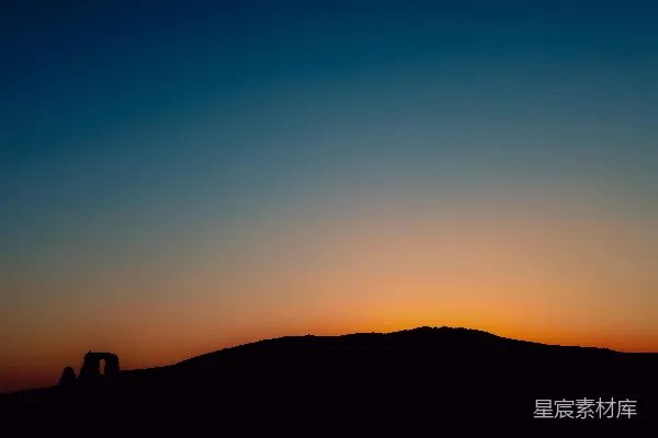 高清摄影 夕阳正挂在一座山的上方，前景中有一匹马。