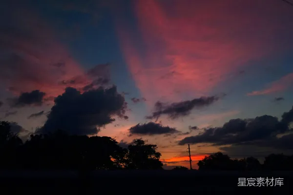 高清摄影 夕阳西下，背景中有云和树木。