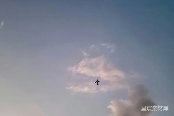 高清摄影 一架飞机在天空中飞行，背景中有月亮。